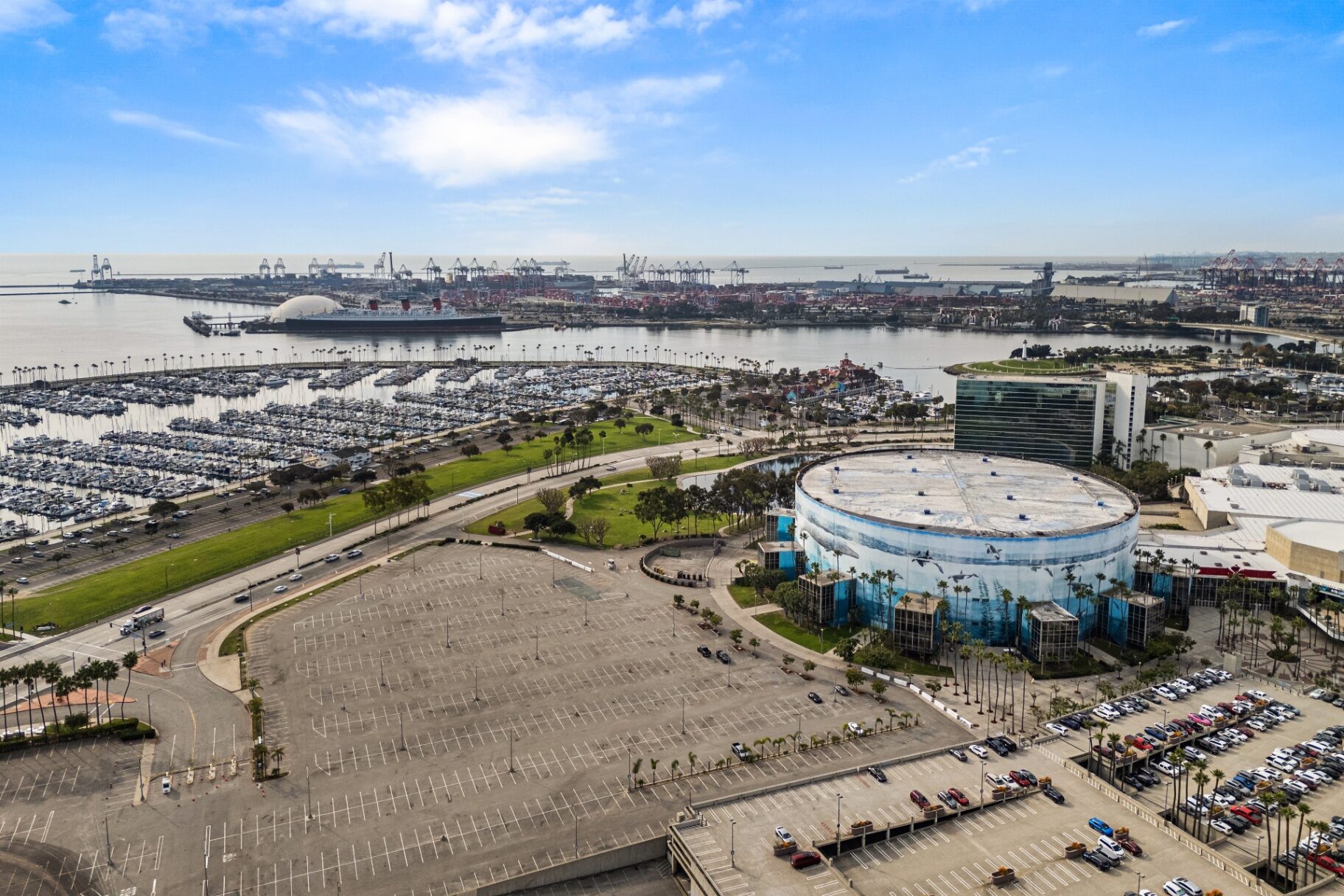 Aerial view of Rainbow Harbor marina, Queen Mary, and Long Beach port from 488 E Ocean Blvd